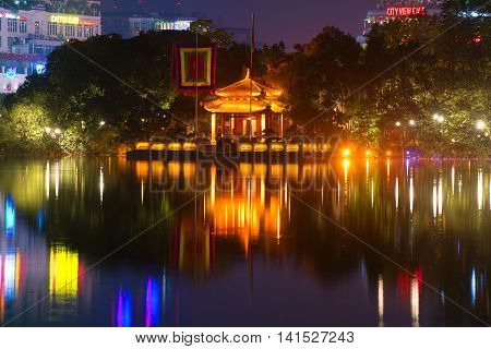 HANOI, VIETNAM - DECEMBER 13, 2015: View on the temple of the jade mountain on Hoan Kiem lake in night illumination. Historical landmark of the city Hanoi, Vietnam