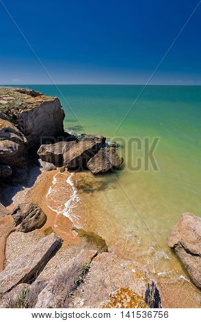 stone cliffs on seashore with blue sky
