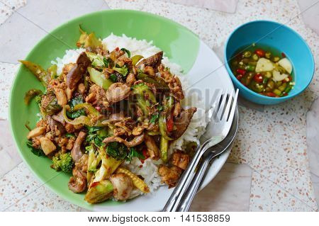 spicy stir-fried chicken innards with basil leaves on rice