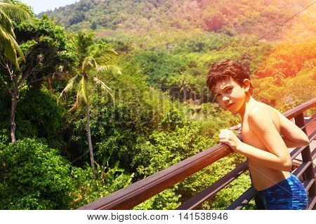 teenage boy on the balkony on the asian jungle forest background close up photo