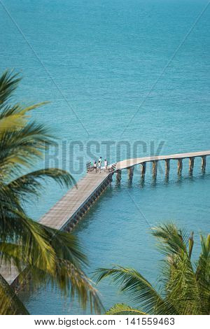 People walking scenic on wooden bridge in beautiful tropicalsea