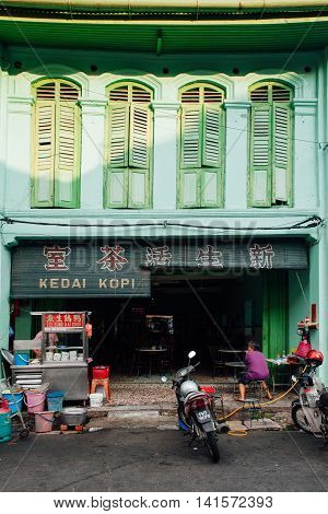 GEORGE TOWN MALAYSIA - MARCH 24: Woman sits at the table in the traditional kopitiam cafe in Chinatown George Town Penang Malaysia on March 24 2016.