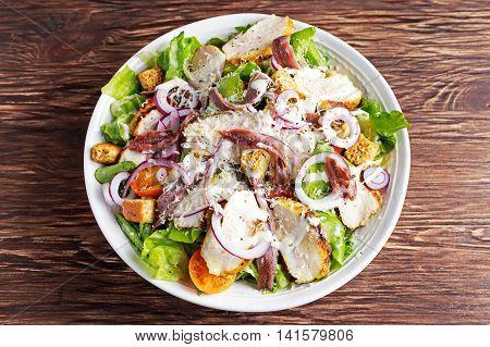 Ceasar salad with grilled chicken fillets, red onion rings, lettuce, orange cherry tomatoes, croutons, grated parmesan cheese, seasoned with anchovy fillets.