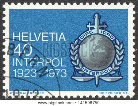MOSCOW RUSSIA - CIRCA APRIL 2016: a post stamp printed in SWITZERLAND shows INTERPOL emblem dedicated to the 50th anniversary of INTERPOL circa 1973