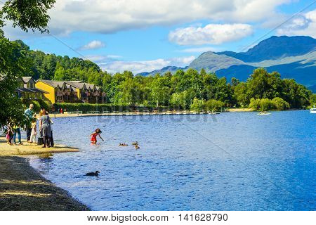 People having fun on a sunny summer day at the Loch Lomond lake in Scotland, 21 July 2016