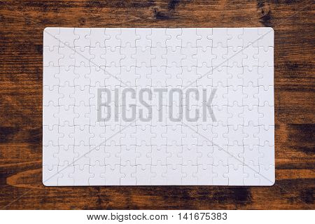 Completed jigsaw puzzle as copy space placed on wooden desk top view