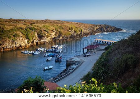 Groups of boats anchored in a calm bay in Porto Covo town, Portugal