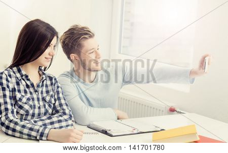 Boy and girl taking selfie on a lesson at chool.