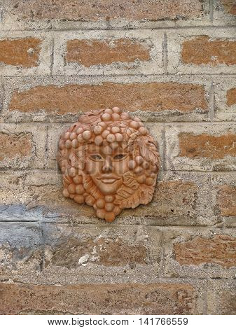 details of architecture historical buildings of Italy. Stone walls and stone mask.