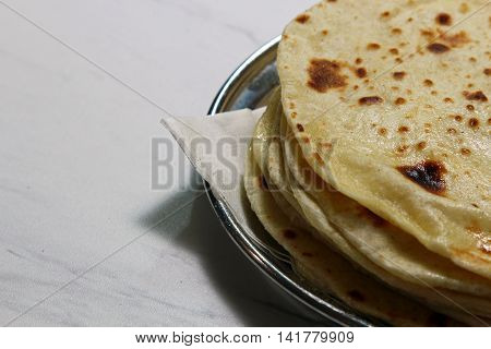 A plate with buttered Kulcha with copy space.