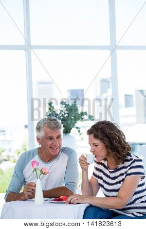 Mature woman with man drinking coffee while sitting at retaurant