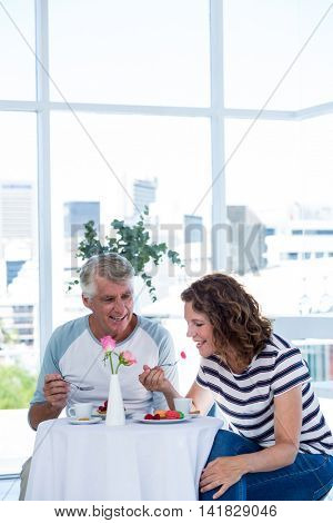 Happu mature couple enjoying food at restaurant