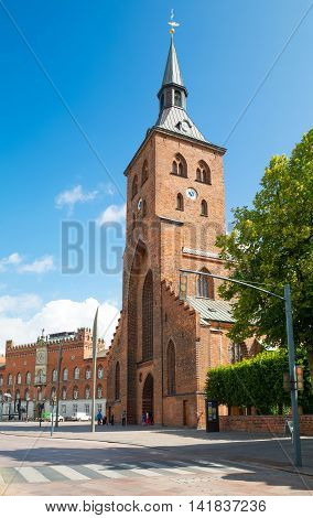 Odense Denmark - July 21 2015: The gothic St. Canute's Cathedral with the City Hall Palace in the background