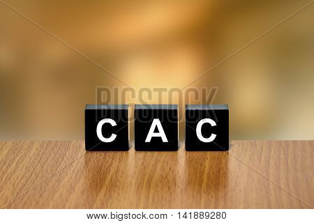 CAC or customer acquisition cost on black block with blurred background