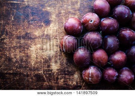 Fresh plums on a dark wood background. Top view image. Ripe Plums Texture