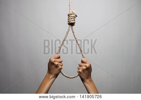 Hands holding rope slipknot in concept suicide