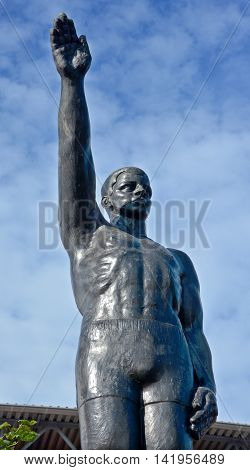 AMSTERDAM NETHERLANDS 02 10 2015: Sculpture by Gra Rueb Official Olympic Salute Stopped Being Popularly Used After WWII Due to Strongly Resembling the Heil Hitler Salute. In front the olympic stadium