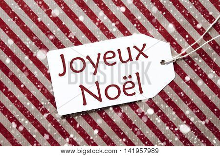 One Label On A Red And Brown Striped Wrapping Paper. Textured Background With Snowflakes. Tag With Ribbon. French Text Joyeux Noel Means Merry Christmas