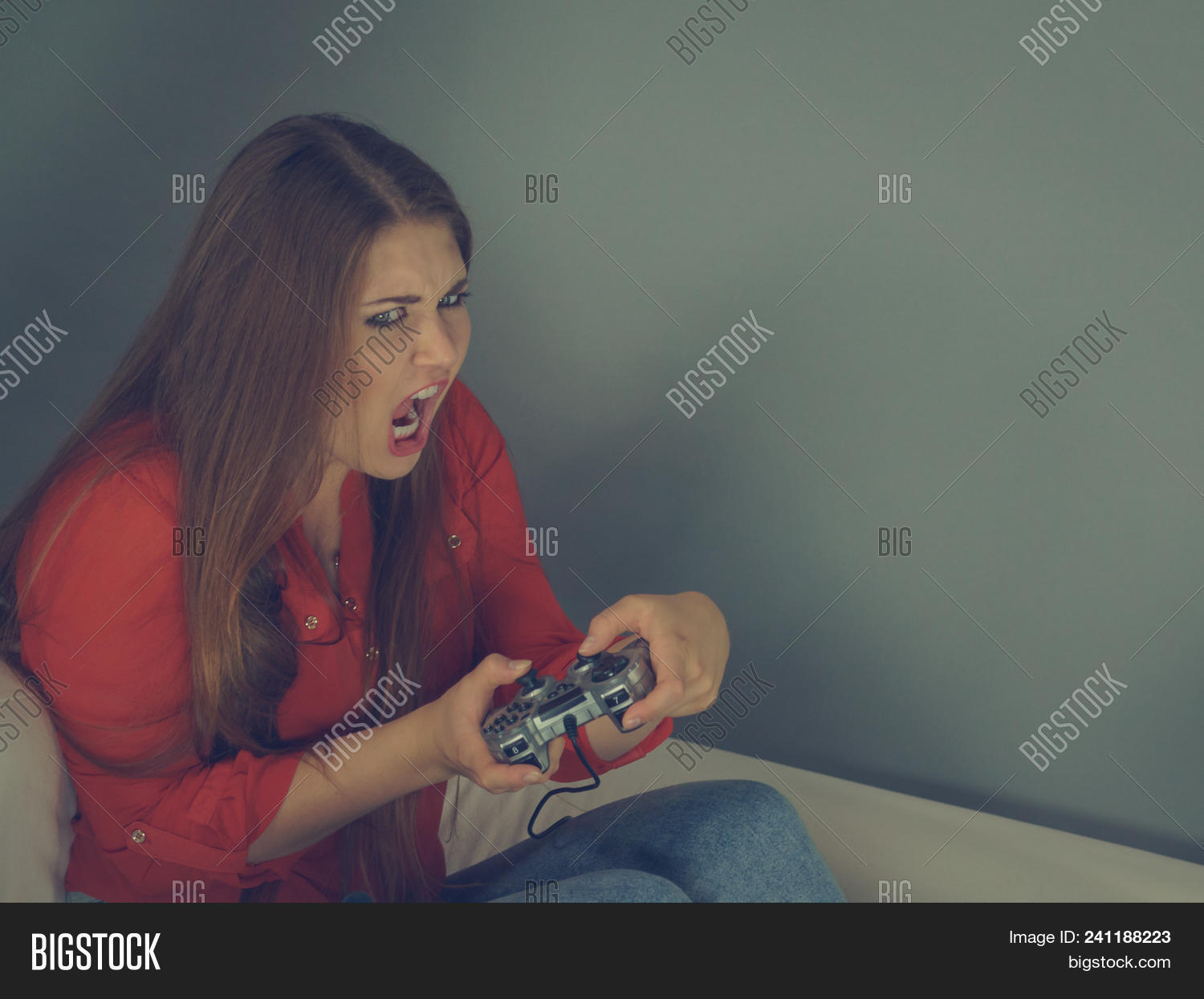 Screaming Emotional Adult Women Playing On The Video Console Holding Game Pad Sitting On Sofa Screaming Emotional Adult Women Playing On The Video Console Holding Game Pad Sitting On Sofa