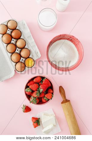 Raw Ingredients For Cooking Strawberry Pie Or Cake On Pink Background  (eggs, Flour, Milk, Sugar, St