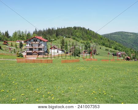 House In Countryside Landscapes Of Grassy Field And Forest At Beskid Mountains Range In European Sal