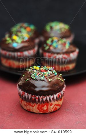 Homebaked Chocolate Muffins For Easter With Colored Conffeti. Dark Background. Sweet Dessert