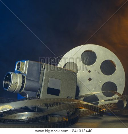 8 Mm Vintage Movie Camera With A Reel Of Film In Smoke. Dark Background