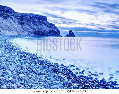 Blue Sunset At Rocky Coast Of Sea. Slow Shutter Speed For Smooth Water Level And Dreamy Effect