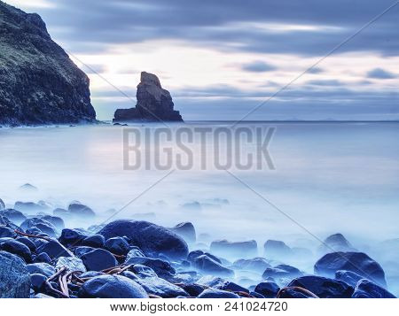 Tranquil Stony Bay In Scotland After Sunset.  Slow Shutter Speed For Smooth Water Level And Dreamy E