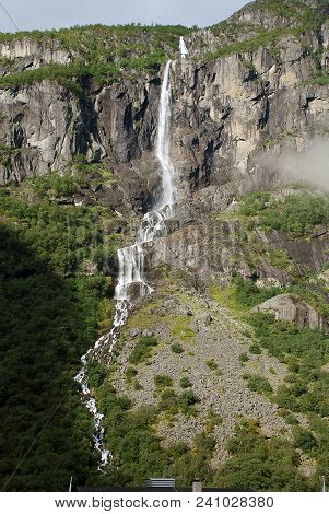 Waterfall Nearby The Briksdalsbreen Glacier, In The South Of Norway