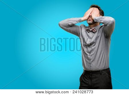 Middle age man, with beard and bow tie stressful keeping hands on head, tired and frustrated