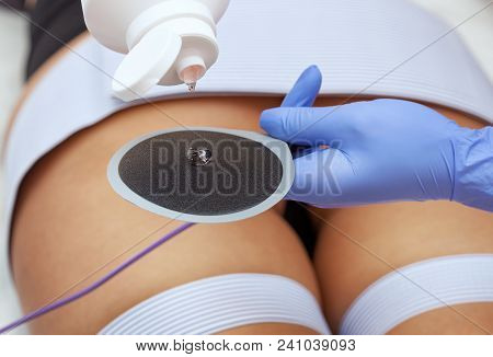 The Procedure Of Myostimulation On The Legs And Buttocks Of A Woman In A Beauty Salon. Caring For Th