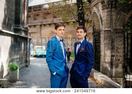 Sunny Wedding Day. Groom And Bestman Groomsmen Dancing And Having Fun Around After Wedding Ceremony 