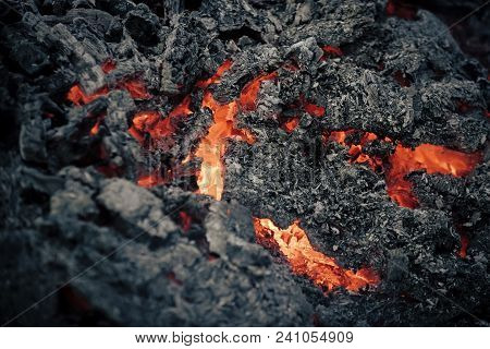 Lava Flame On Black Ash Background. Magma Textured Molten Rock Surface. Volcano, Fire, Crust. Danger