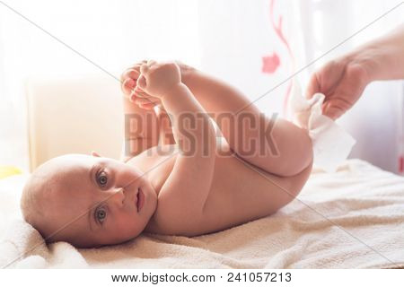 Hygiene - young momy wiping the baby skin with wet wipes. Cleaning wipe, pure, clean