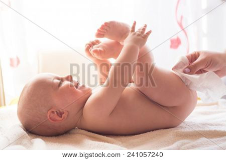 Hygiene - young momy wiping the baby skin with wet wipes. Cleaning wipe, pure, clean