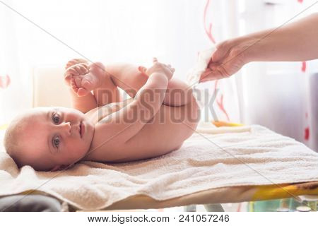 Hygiene - young momy wiping the baby skin with wet wipes. Cleaning wipe, pure, clean