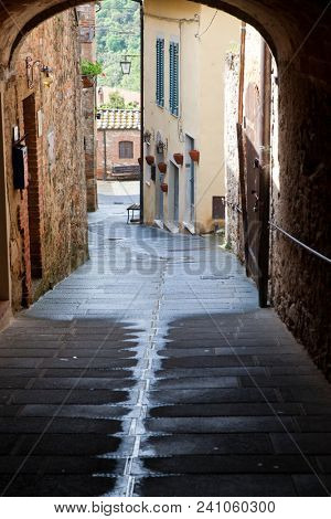medieval narrow sreet in asciano, Italy