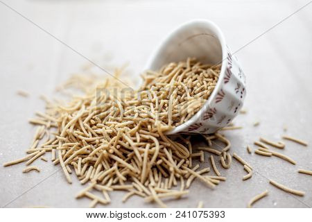 Popular Indian & Gujarati Dish Aloo Sev Or Potato Sev Or Mint Flavored Sev In A Bowl On A Brown Surf