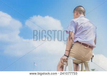 Student Acting Like A Superhero On Top Of Stepladder In School.