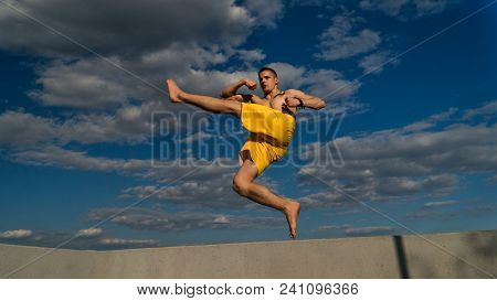 Tricking On Street. Martial Arts. Man Is Making High Jab In Jump Barefoot. Shooted From Bottom Fores