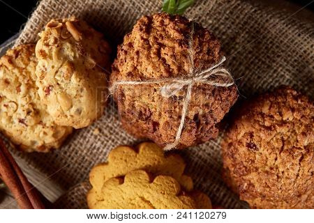 Conceptual Composition With Assortment Of Cookies On Burlap Napkin Covering A Wooden Barrel Over Rus