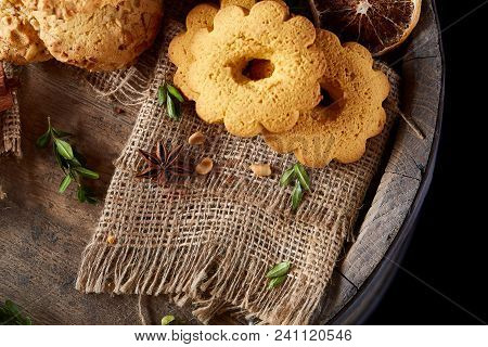 Conceptual Composition With Assortment Of Cookies On Burlap Napkin Covering A Wooden Barrel Over Rus