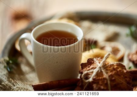 Conceptual Festive Composition With A Cup Of Hot Tea, A Large Set Of Cookies, Cinnamon Sticks Bunch 