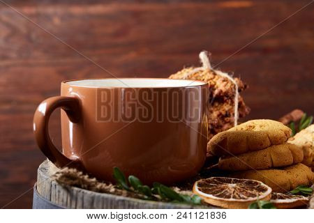 Festive Composition With A Mug Of Hot Tea, Assortment Of Cookies, Cinnamon Sticks Bunch And Dried Or