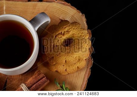 Christmas Concept With A White Porcelain Cup Of Hot Tea, A Large Set Of Cookies, Cinnamon Sticks Bun