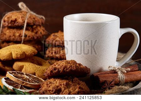 Conceptual Festive Composition With A Cup Of Hot Tea, A Large Set Of Cookies, Cinnamon Sticks Bunch 
