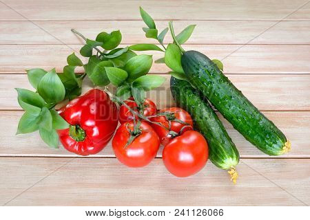 Fresh Vegetables From The Garden On A Wooden Table. Tomatoes, Cucumbers And Sweet Peppers