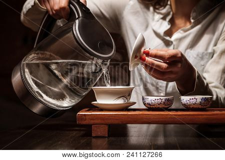 Cropped shot of woman brewing tea in traditional chinese teaware.