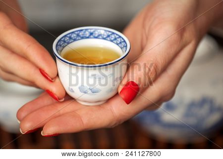 Cropped Shot Of Woman Pouring Tea In Traditional Chinese Teaware.